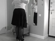 A mature, fat milf with big, saggy tits is changing clothes in front of the mirror.